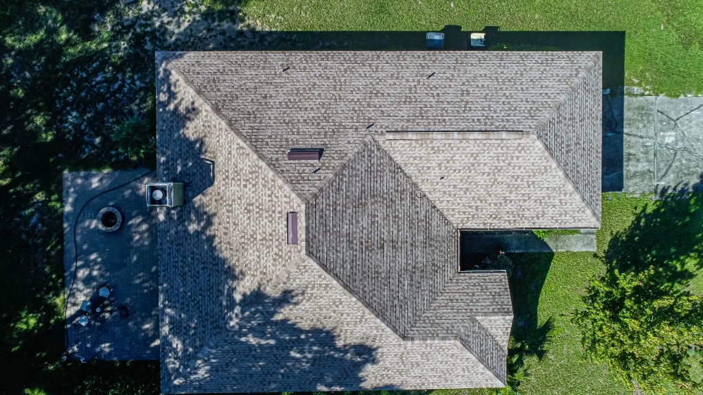 Aerial view of a completed Stronghold Roofing warm tan architectural shingle roof replacement on a Florida home