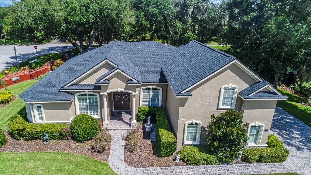 Aerial view of a completed Stronghold Roofing charcoal architectural shingle roof on a Florida two-story estate home