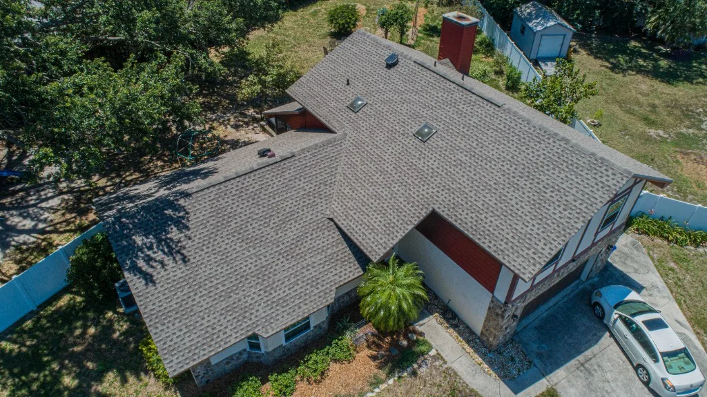 Aerial view of a completed Stronghold Roofing warm brown architectural shingle roof on a Florida Tudor-style home