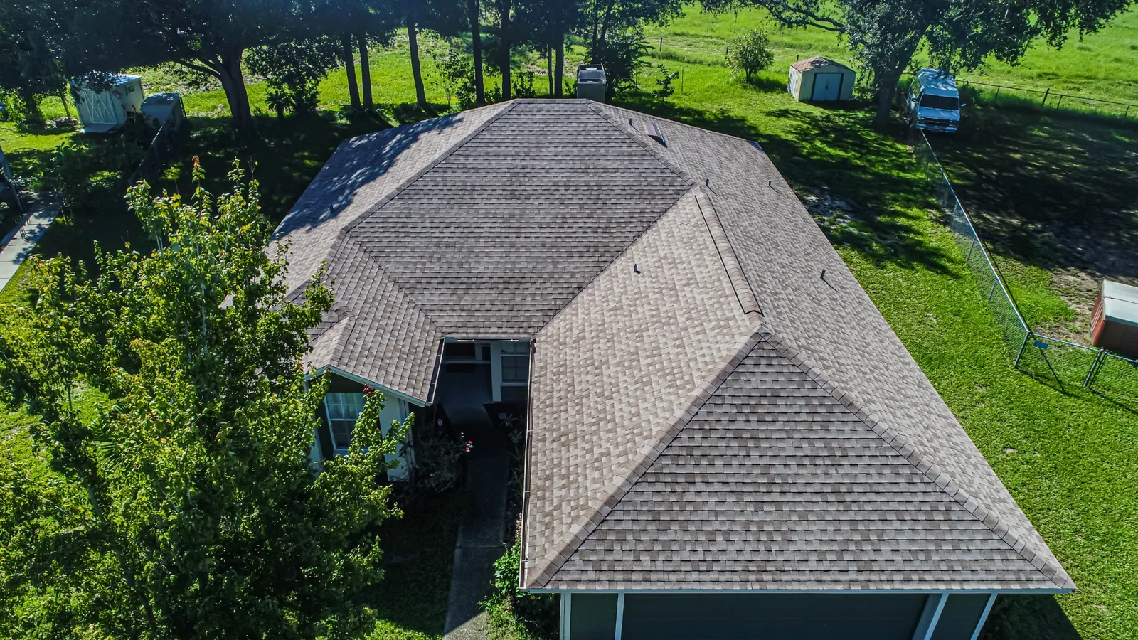 Aerial view of a Stronghold shingle roof replacement on a Florida home framed by palms