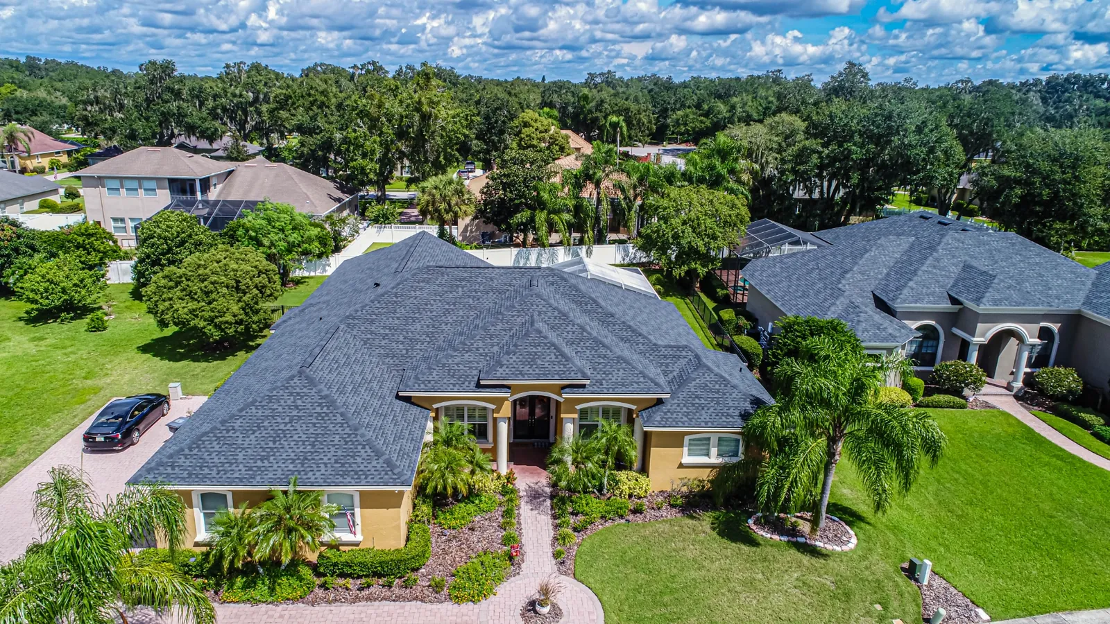 Aerial view of a Stronghold-installed charcoal architectural shingle roof on a Florida home