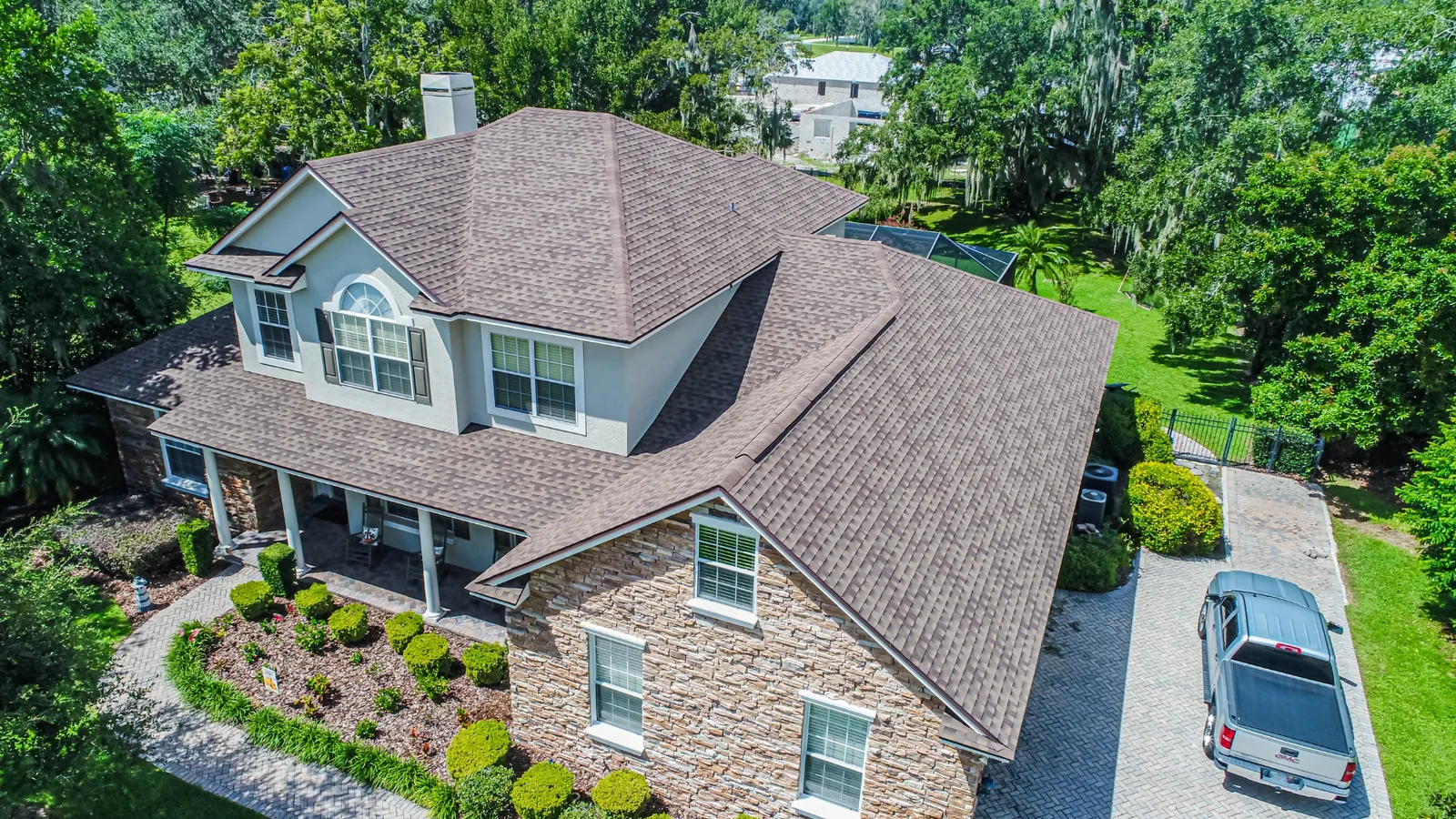 Aerial view of a Stronghold charcoal shingle re-roof on a Florida home with lush palms