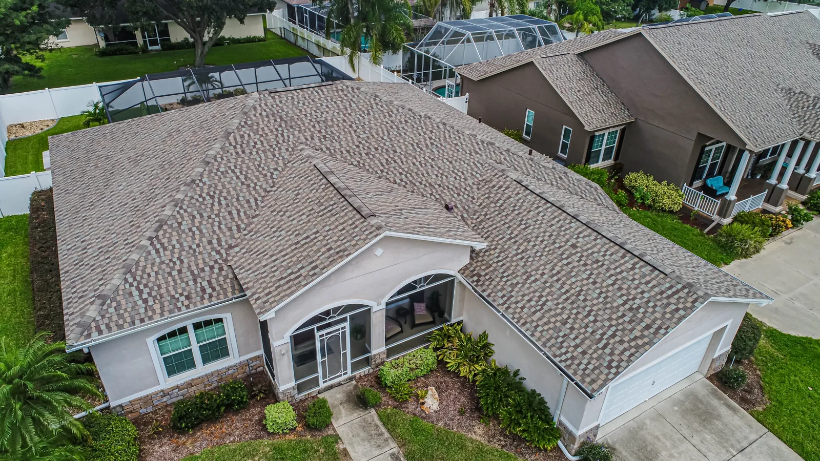 Aerial view of a Stronghold architectural shingle roof on a Florida home with lanai screen enclosure