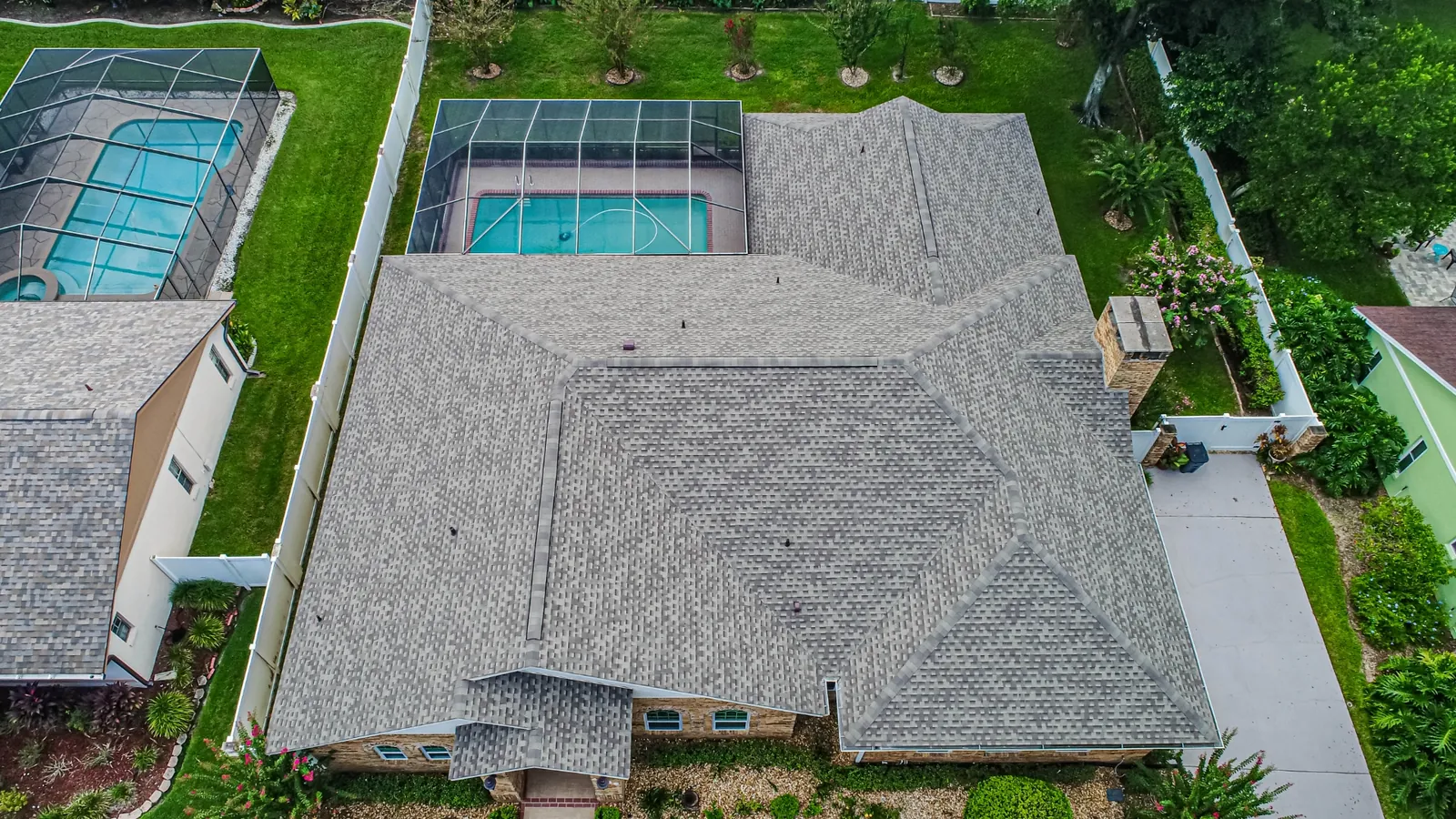 Aerial view of a Stronghold architectural shingle roof on a Florida home with paver driveway