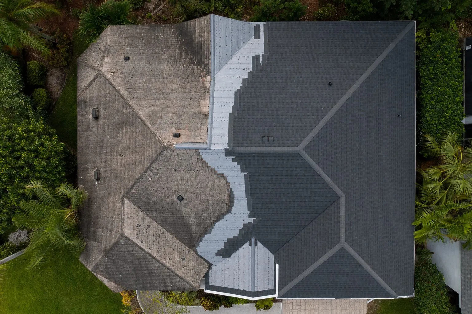 Half old, half new charcoal shingles mid-replacement, drone view