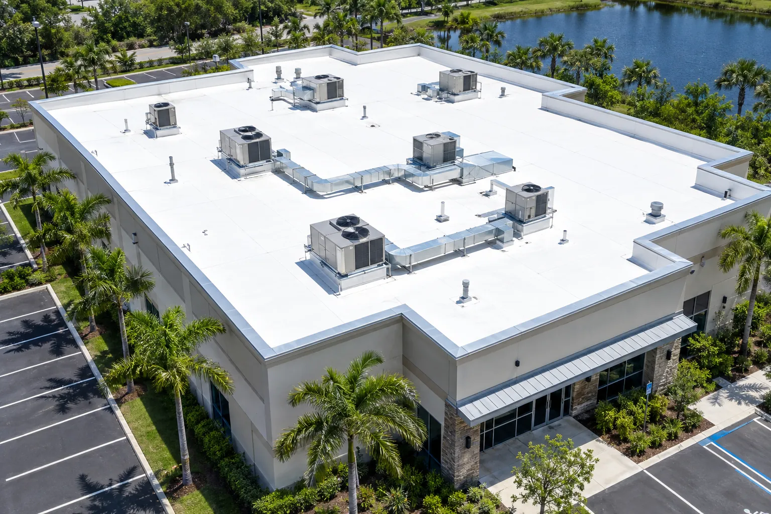 Aerial view of a Florida commercial building with a bright white TPO flat roof and rooftop HVAC units