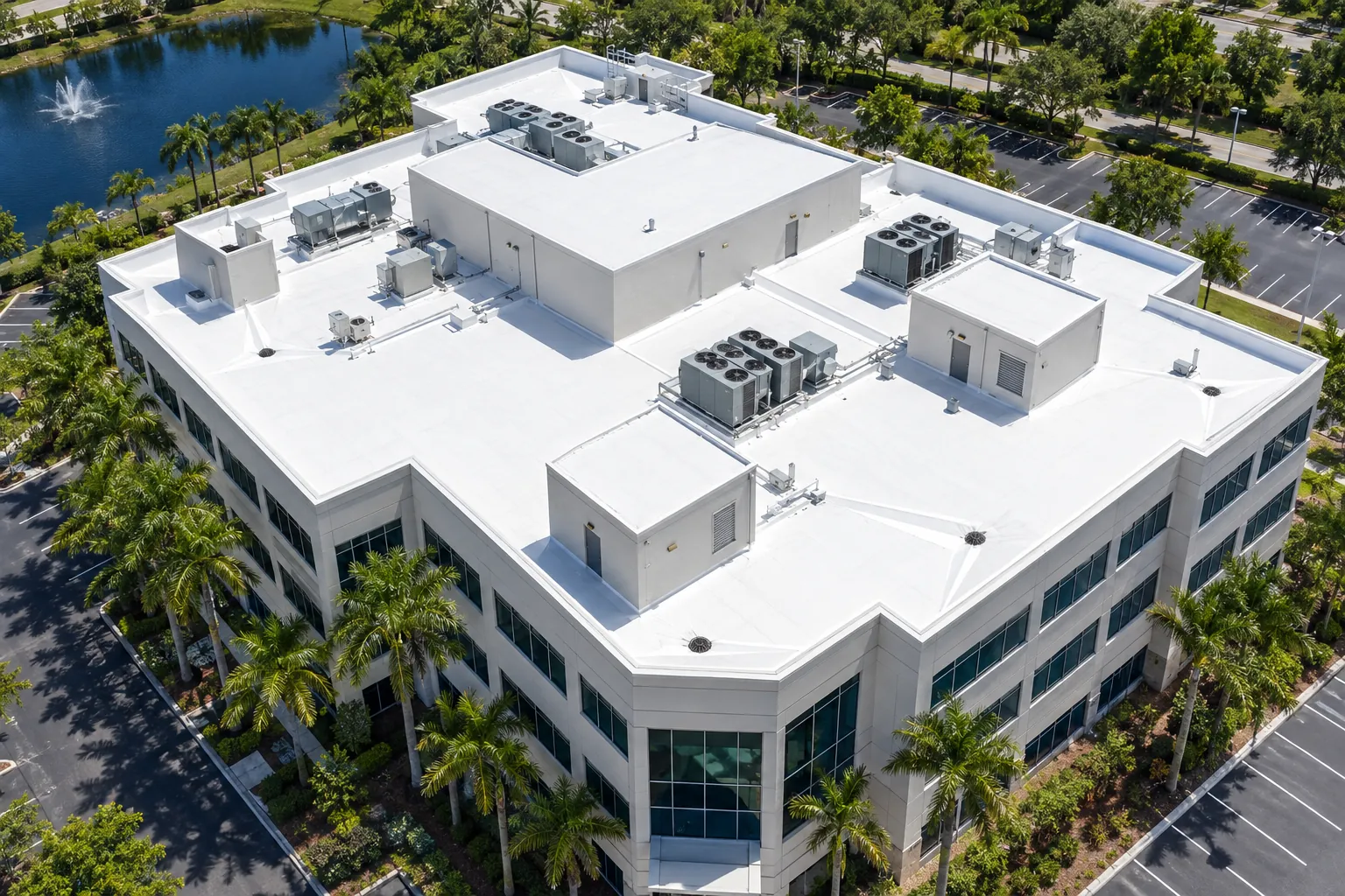 Aerial view of a Florida office building with a complex white TPO flat roof and mechanical penthouses