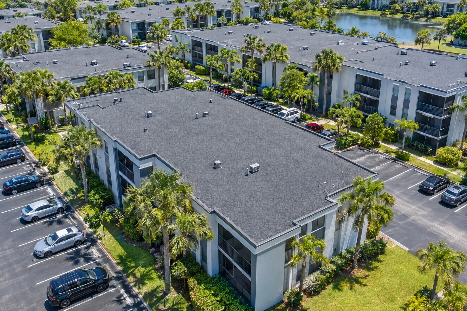Aerial view of a Florida apartment complex with dark gray modified bitumen flat roofs