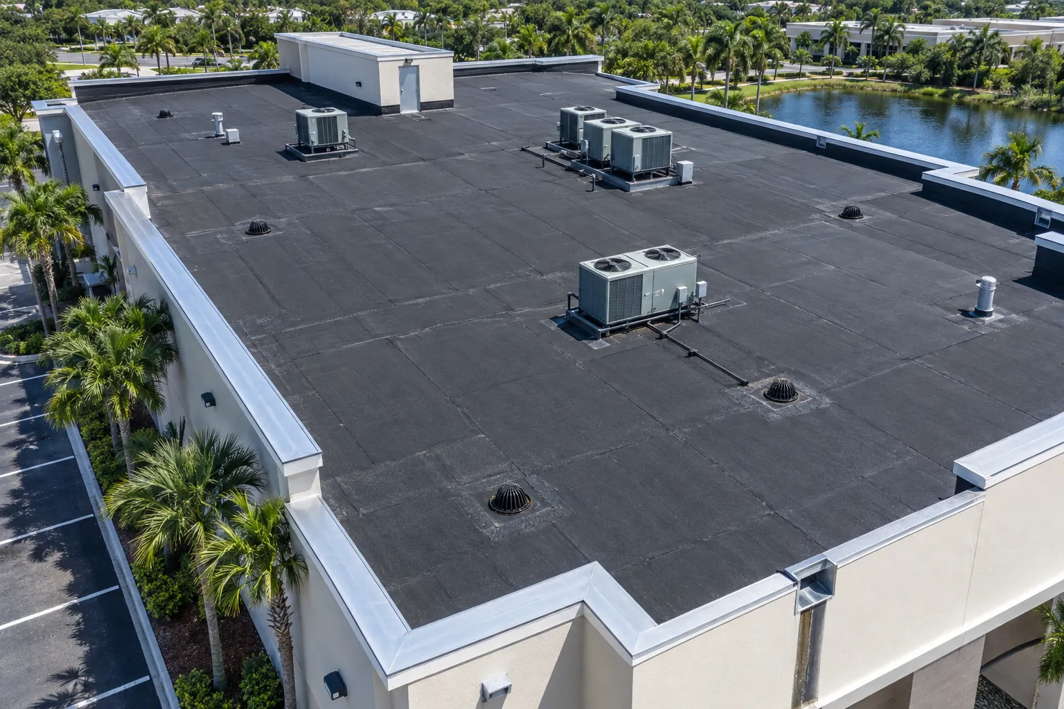 Aerial view of a Florida commercial flat roof with dark modified bitumen surface and roof drains