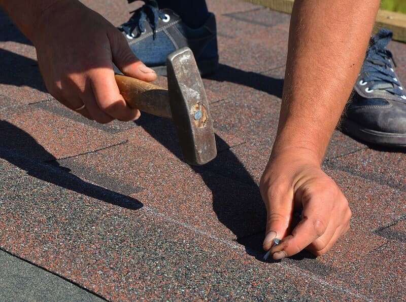 Installing asphalt shingles by a roofer