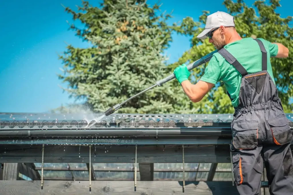 A man cleaning gutter with water pressure in Lakeland