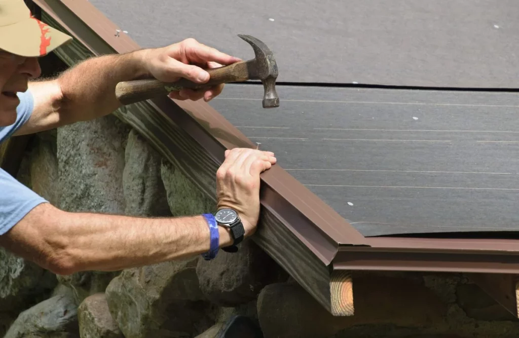 A roofer fixing a loose nail on roof in Lakeland Florida