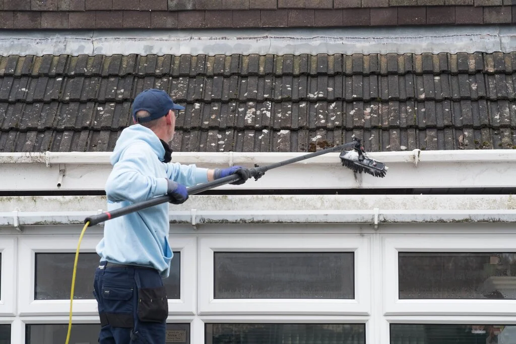 a man soft washing roof in Lakeland