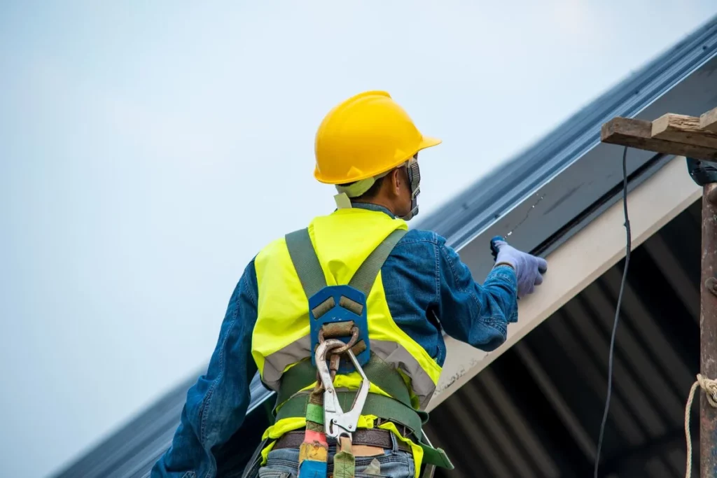 A professional local roofer maintaining a metal roof in Lakeland