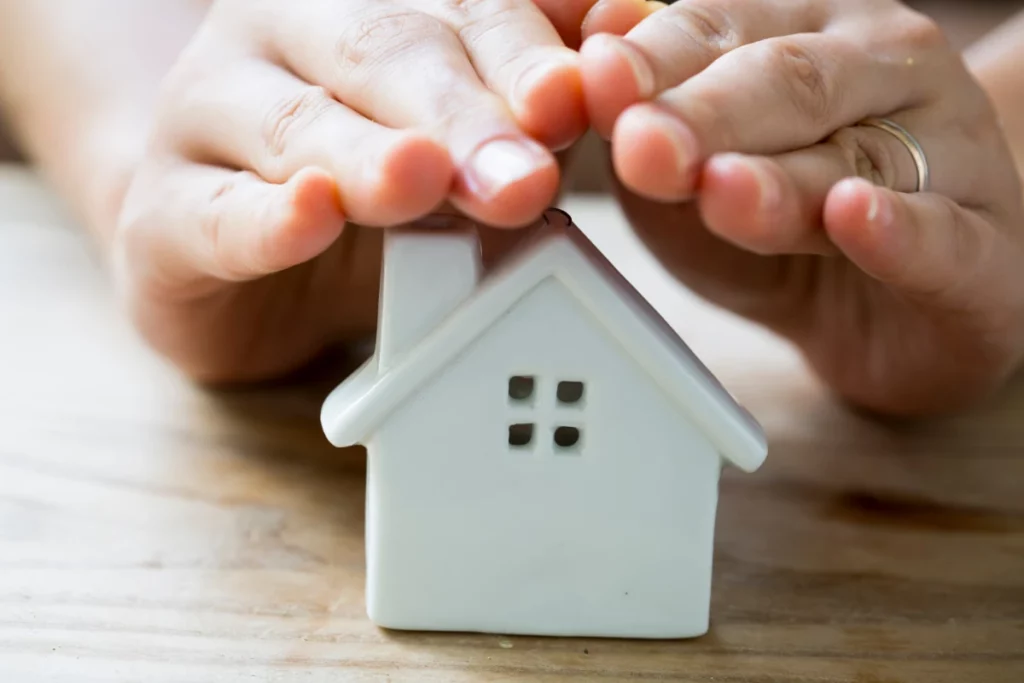 holding hand on the top of the small house